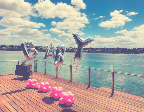 træterasse ved vandet pyntet med bogstav balloner