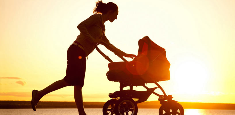mor med barnevogn i solnedgang