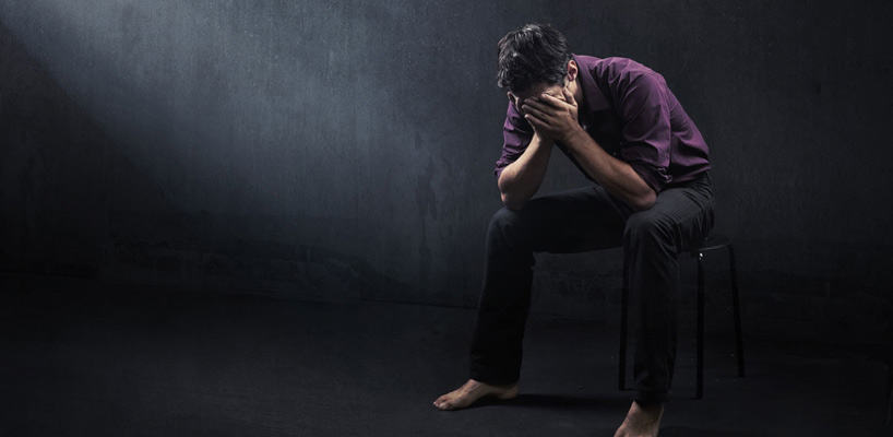deprimeret mand sidder på stol