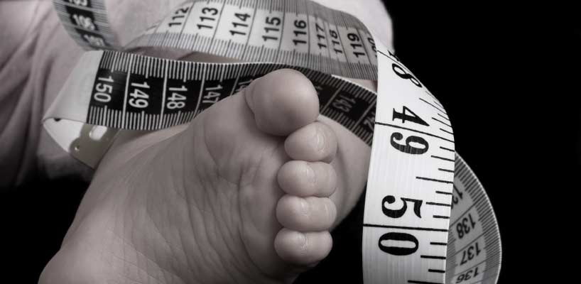 børnefod og målebånd