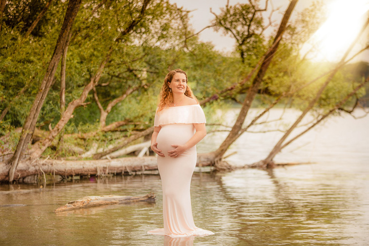 gravid kvinde i hvid kjole i skov