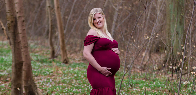 gravid kvinde i skov i bordeaux kjole