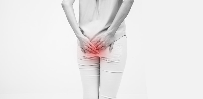 kvinde tager sig til rumpen