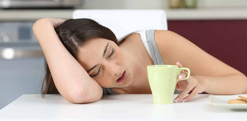 træt kvinde sover ved bord