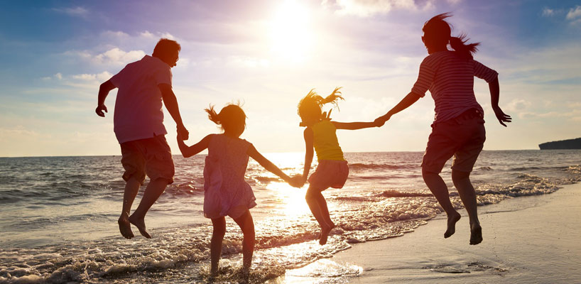 familie på stranden i solnedgang