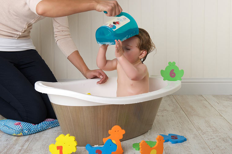 baby får vasket hår med shampoo rinse cup