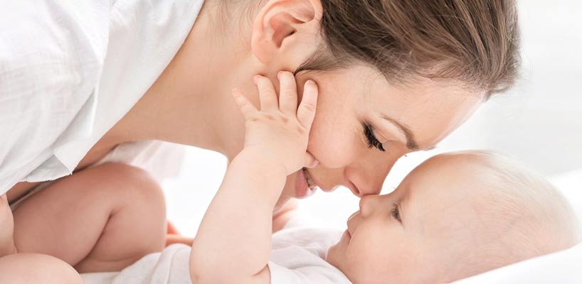 mor og baby ligger tæt med ansigterne