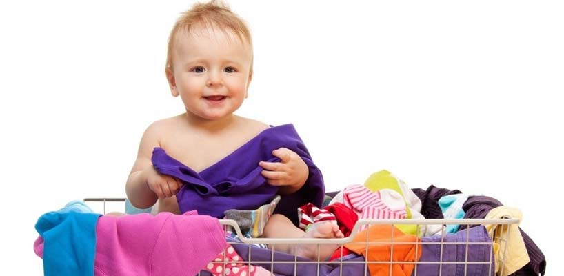 barn i indkøbsvogn med tøj