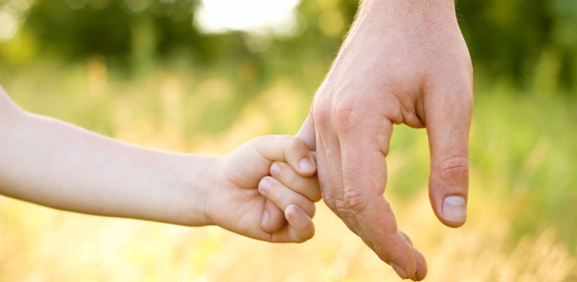 barn holder om voksens finger